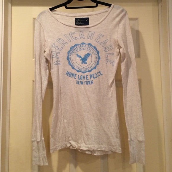 Cream colored long sleeve shirt with blue writing