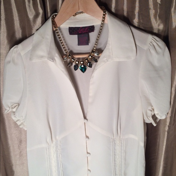 Blouse with buttons and lace detail.