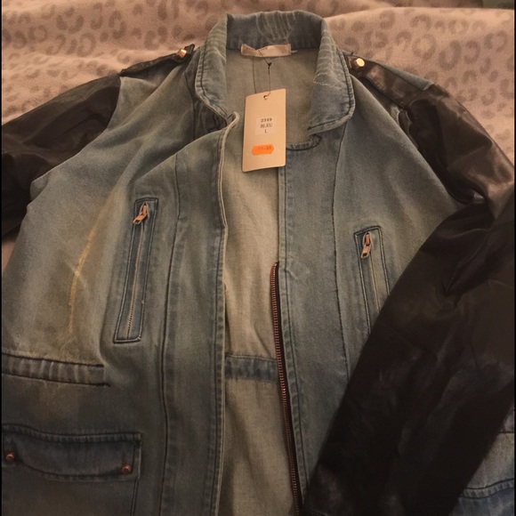 Distressed jean jacket with faux leather sleeves