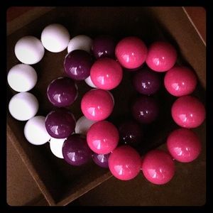 Three big bead bracelets in white, purple, pink