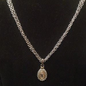 Silver color necklace with a hanging pendent.