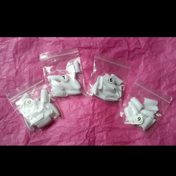 Four baggies of white acrylic tips.