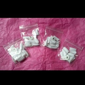 Four baggies of white acrylic tips.