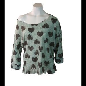 Green off-shoulder sweater with black hearts