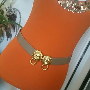 Gold lion head belts on beige leather
