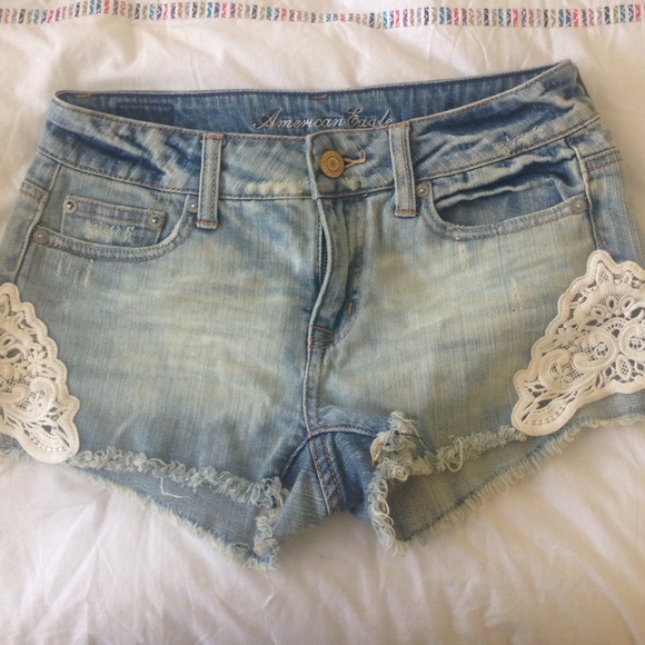 Denim shorts with lace appliqué on sides.