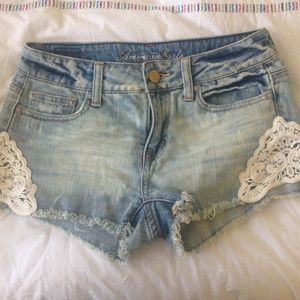 Denim shorts with lace appliqué on sides.