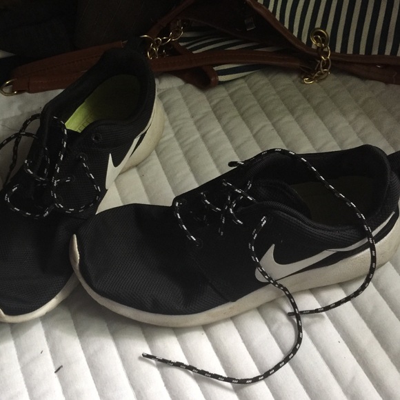 A pair of black and white Roshe runs .