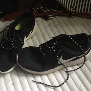 A pair of black and white Roshe runs .