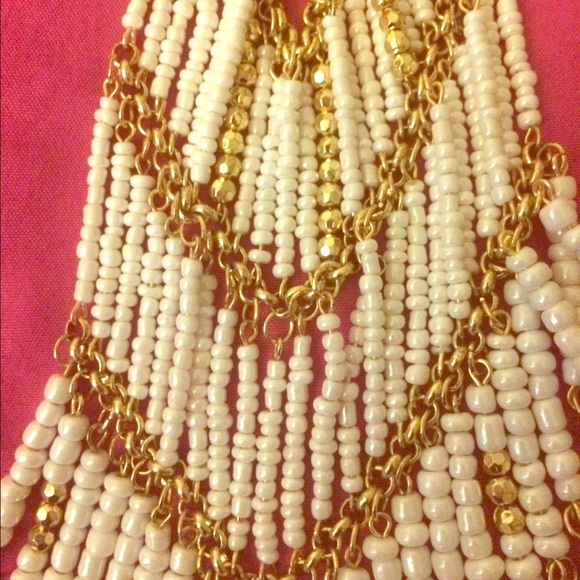 White beads and gold chains and leaves.