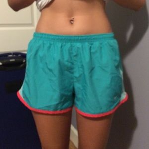 Green and coral pipping Nike running shorts