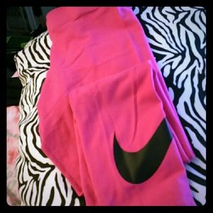 Pink nike leggings with black Nike sign on leg