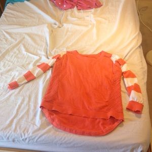A elbow length orange shirt with stripped sleeves.