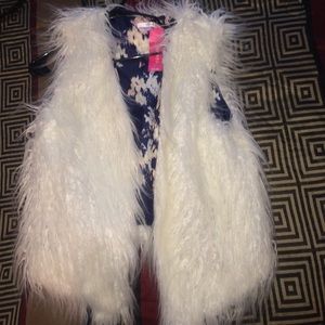 All white faux fur vest.