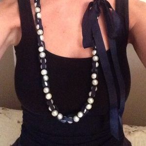 Pearl necklace with navy ribbon intertwined