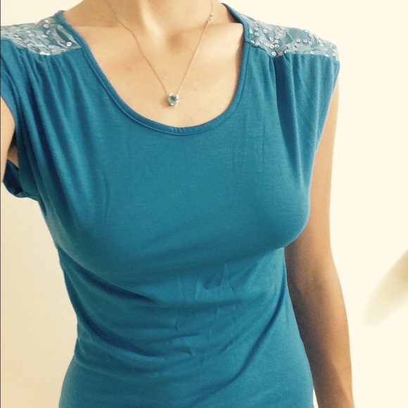 Blue top with sequins on the shoulder.