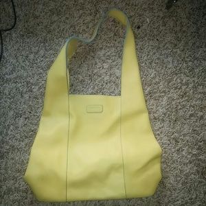 Yellow baekgaard purse with teal accent .