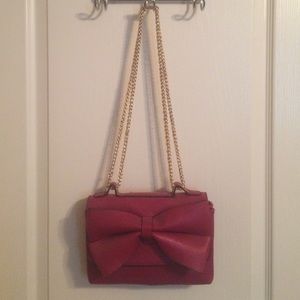 Maroon colored purse with a big bow