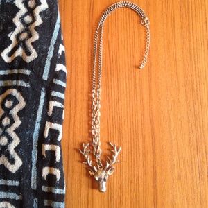 Brass color stag's head necklace.
