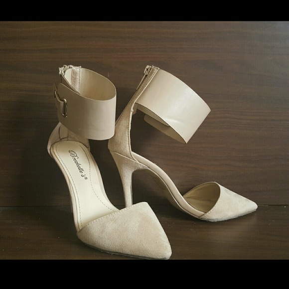 Pointed toe ankle strap heels in nude.