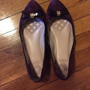 Violet flat shoe with patent leather bow tie.
