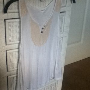 A white tank top with gold lace embellishments.