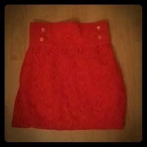 Red high-waisted lace skirt with gold buttons.