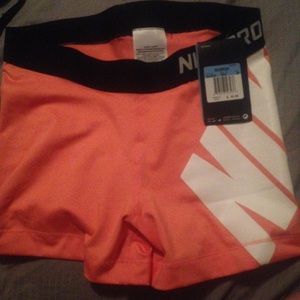 Brand new Nike pros. Size medium, 3" coral color