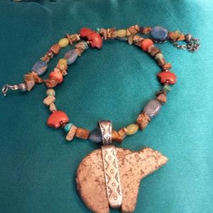 Polished stone necklace with pendant.