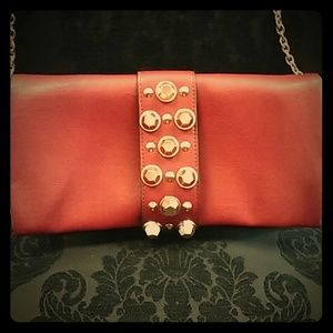 Burgundy clutch purse with long chain.
