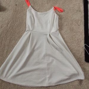 A classic white sundress with hot pink straps