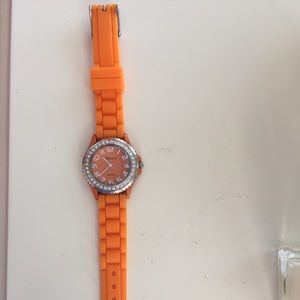 Orange watch with diamond embedded outer ring.