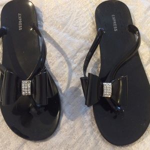 Express plastic black flip flops.