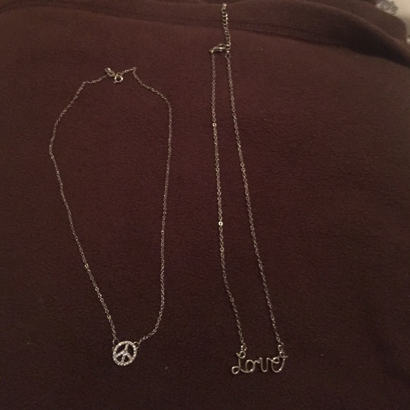 2 silver necklaces.(Left)- peace sign (right)-love