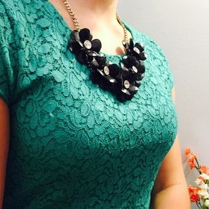 Black flower necklace with a silver chain.