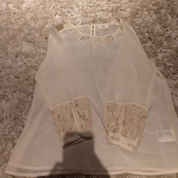 Creme colored long sleeve top with designs