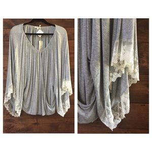 Grey top with lace sleeves .