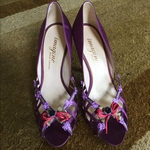 Satin purple shoes with flower details.