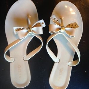 Tan flip flops with studded bow