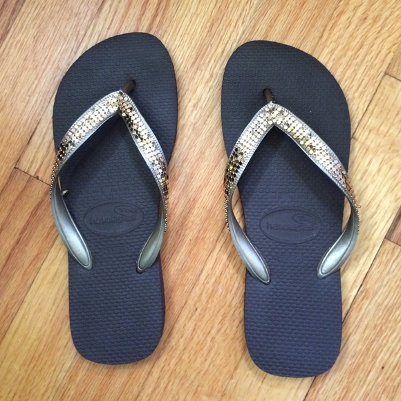 Havaianas brown flip flips with gold straps.