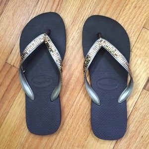 Havaianas brown flip flips with gold straps.