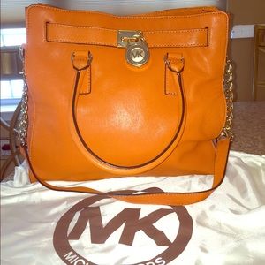 A  Michael Kors Orange purse.