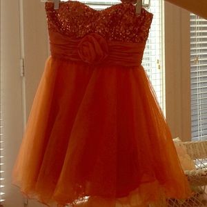 A bright orange dress with sequins on top