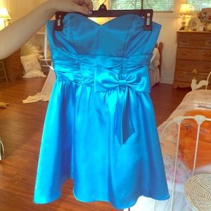 A silky blue dress with a flower on the front