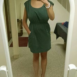 Army green dress with silver zipper pockets.