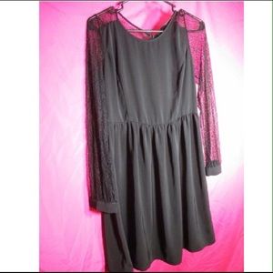 Black knee length dress with lace sleeves.