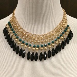 Green and beige beads with black water drops