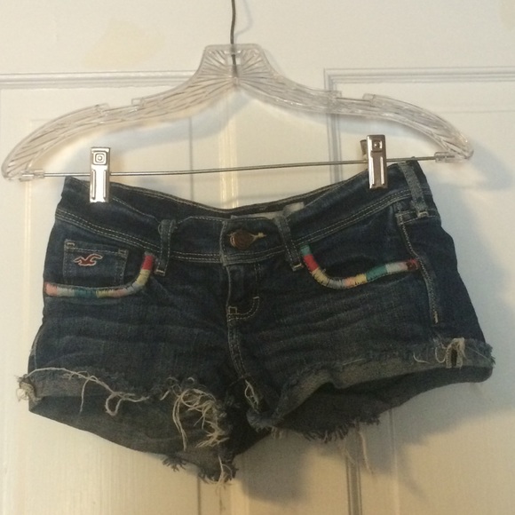 Distressed denim shorts with colorful pockets.