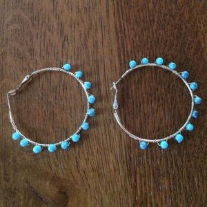 Turquoise beads with gold hoop earring.