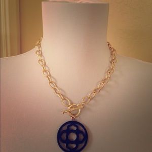 Gold chain necklace with navy blue resin toggle.